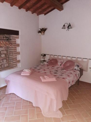 a bedroom with a large bed with pink sheets at Bed & Breakfast Villa Monterosso in Sassoferrato
