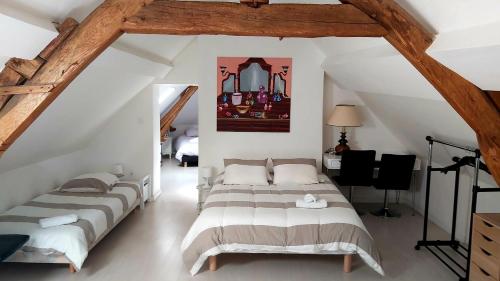 um quarto com 4 camas num sótão em La Pierre Précieuse em Château-Thierry