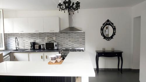 a kitchen with white cabinets and a counter top at La Pierre Précieuse in Château-Thierry