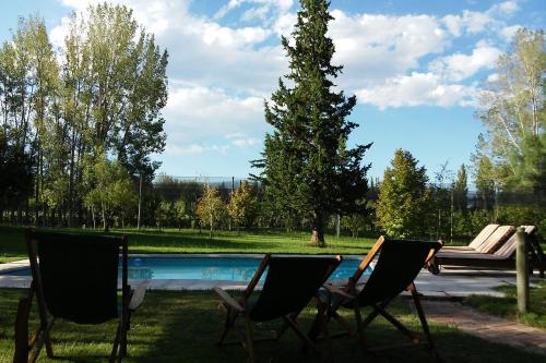a couple of chairs sitting next to a swimming pool at Finca La Encantada in San Rafael
