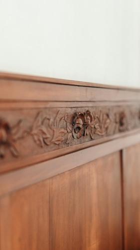 a wooden dresser with a carving on it at Puleera Boutique Hotel in Giarre