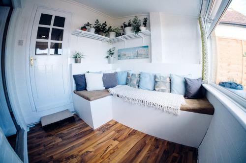 a living room with a couch and a window at Bijou Annexe, Sea View, Private Entrance & Parking - FOLKESTONE in Folkestone