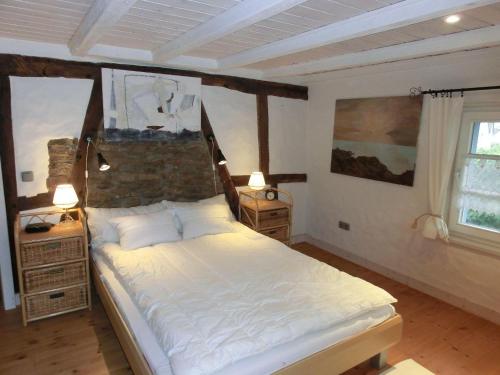 a bedroom with a large white bed in a room at Haus-Hoeppches in Blankenheim
