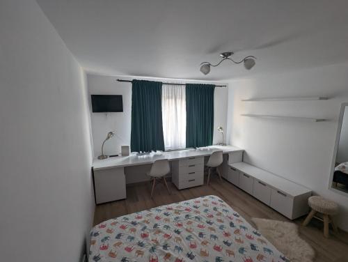 a bedroom with a bed and a desk and a window at Tin Apartment in Vatra Dornei