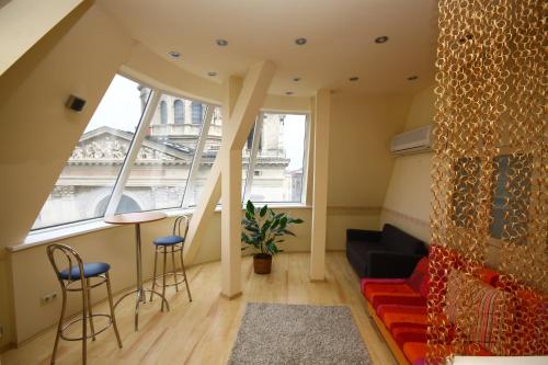 a living room with a large window and a couch at Pal's Hostel and Apartments in Budapest