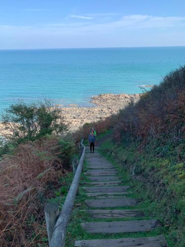 a person walking down a path near the ocean at La petite duchesse - jaccuzzi in Plérin