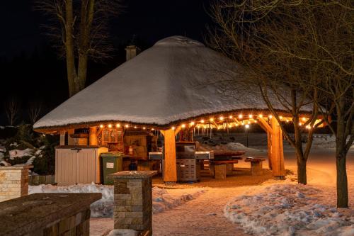 a gazebo with lights in the snow at night at REZYDENCJA SPISZ dom 12 osób, podgrzewany basen, sauna, jacuzzi- velo Czorsztyn, Niedzica in Niedzica Zamek