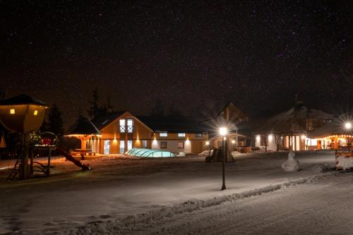 a group of houses in the snow at night at REZYDENCJA SPISZ dom 12 osób, podgrzewany basen, sauna, jacuzzi- velo Czorsztyn, Niedzica in Niedzica Zamek