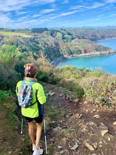 a woman with a backpack standing on a hill overlooking a lake at La petite duchesse - jaccuzzi in Plérin