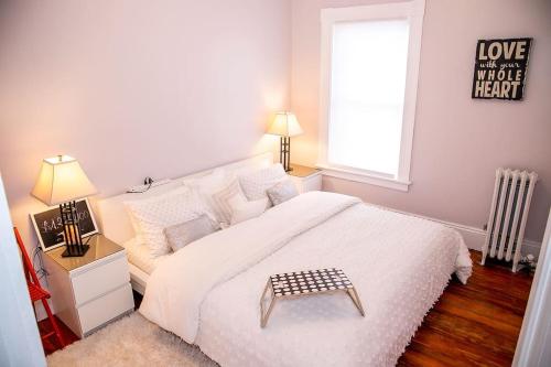 a bedroom with a large white bed and a window at 521 Smith Steet LLC in Providence