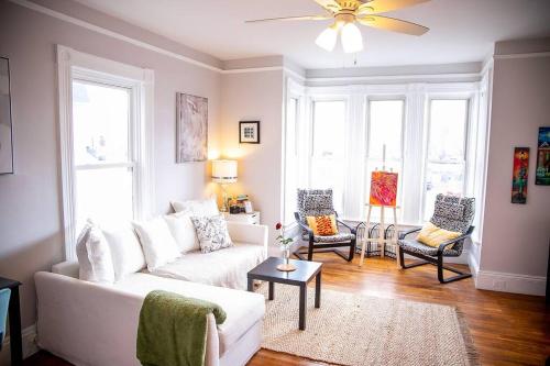 a living room with a white couch and two chairs at 521 Smith Steet LLC in Providence