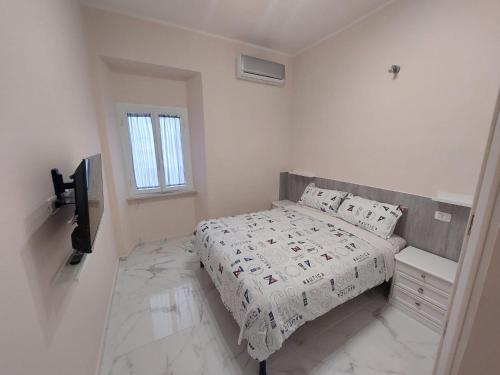 Habitación blanca con cama y TV en EL MAR casa vacanza Lavinio mare, en Anzio