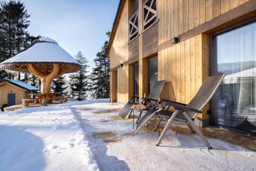 a group of chairs sitting outside of a building in the snow at REZYDENCJA SPISZ dom 12 osób, podgrzewany basen, sauna, jacuzzi- velo Czorsztyn, Niedzica in Niedzica Zamek