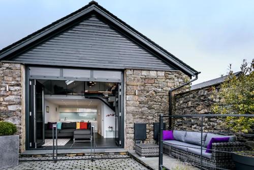 a house with a large glass window with a couch at The Old Roller Shed in Cartmel