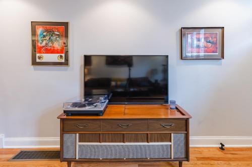 a wooden dresser in a room with two pictures on the wall at Bedroom in thoughtfully decorated East Passyunk home (South Philadelphia) in Philadelphia