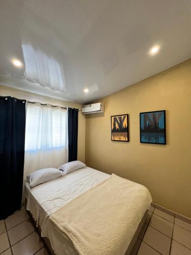 a bedroom with a bed and a window at CORONADO VILLA VICTORIA in San Carlos