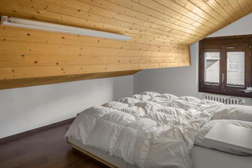 ベットマーアルプにあるAlpenglück 51の木製天井の客室の大型ベッド1台分です。