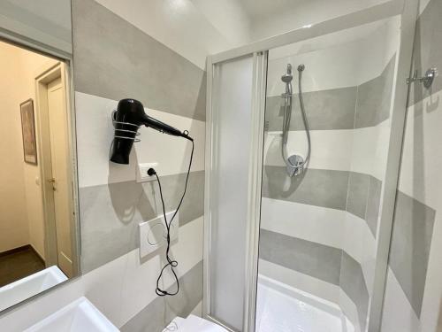 La salle de bains est pourvue d'une douche et d'un sèche-cheveux noir. dans l'établissement La casa dell’artista - Levanto, 5 Terre, à Levanto