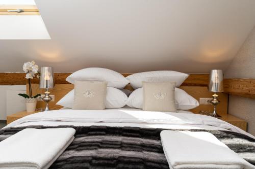 a bedroom with a large bed with white pillows at REZYDENCJA SPISZ dom 12 osób, podgrzewany basen, sauna, jacuzzi- velo Czorsztyn, Niedzica in Niedzica Zamek