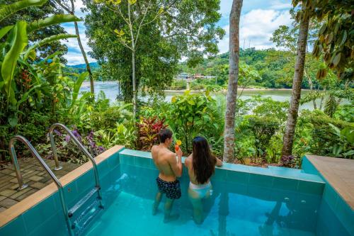 a man and a woman standing in a swimming pool at El Jardin Lodge & Spa in Puerto Misahuallí