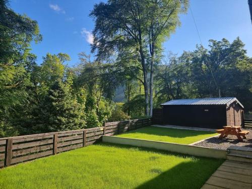 a backyard with a fence and a shed at Stunning views in Lochgoilhead