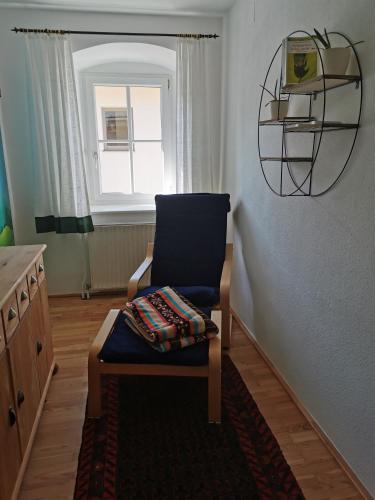 a blue chair sitting in a room with a window at Ferdlhof Ferienwohnung in Ulrichsberg