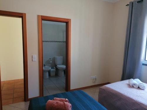 a bedroom with a bathroom with a toilet and a mirror at Despertar do Sol in Santa Cruz