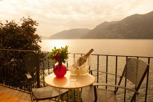 a table with a bottle of wine and a glass at Nest on The Lake in Marone