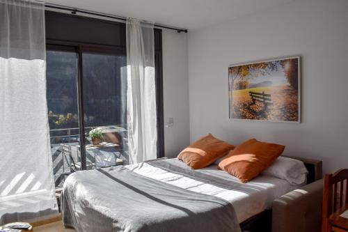 um quarto com uma cama e uma grande janela em Apartament Mufló Apartamento encantador con vistas espectaculares a la X de Grandvalira em El Tarter