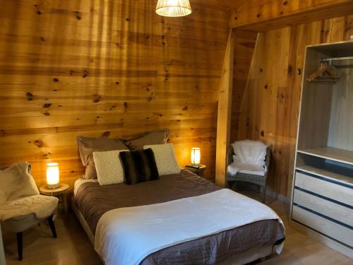 シュノーヴにあるChambres d'Hôte Dijon Clair de Luneの木製の壁のベッドルーム1室