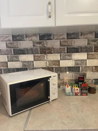 a microwave oven sitting next to a brick wall at Apartman Maki in Sarajevo