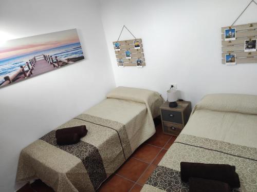 a bedroom with two beds and a picture on the wall at Apartamento Casa Belen in Conil