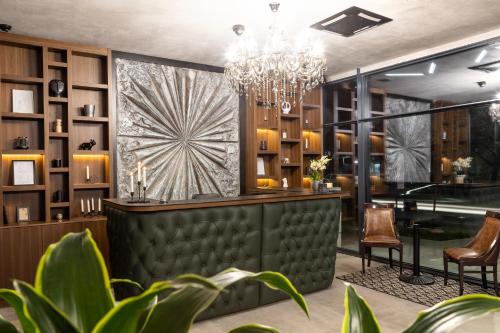 a bar with a chandelier and plants at Abrazo Sofia Hotel by HMG in Sofia