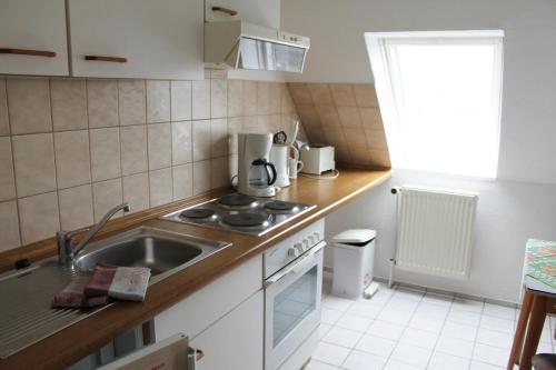 a small kitchen with a sink and a stove at Haus Strandgang, Whg 11 in Kellenhusen