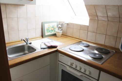 a small kitchen with a sink and a stove at Haus Strandgang, Whg 12 in Kellenhusen