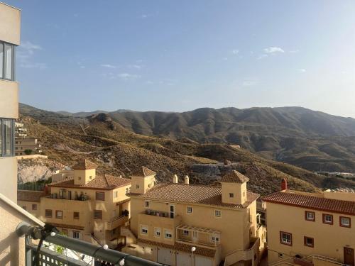 vistas a una ciudad con montañas en el fondo en Apartamento nuevo con piscina en la envía golf aguadulce Almería, en La Envía