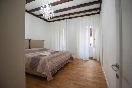 een slaapkamer met een bed en een kroonluchter bij Splendido appartamento nel centro di Roma, Monti in Rome