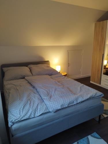 a bed with a blue comforter in a bedroom at Ferienhaus in Handewitt kurz vor dänischen Grenze in Handewitt