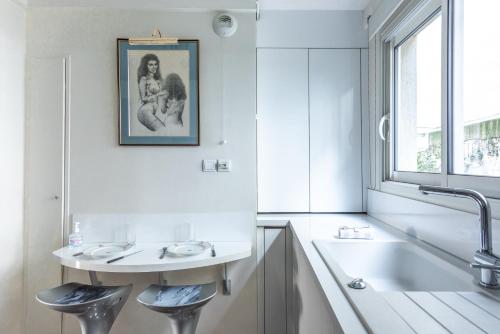 La salle de bains blanche est pourvue d'un lavabo et d'une baignoire. dans l'établissement Amazing Apartment - 6 guests - 5 min from Gare de Lyon, à Paris