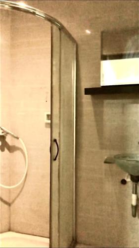 łazienka z drzwiami prysznicowymi i umywalką w obiekcie Sacca Studio Home in Benoa w mieście Ujung