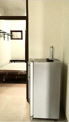 a small refrigerator in a room with a bed at Sacca Studio Home in Benoa in Ujung