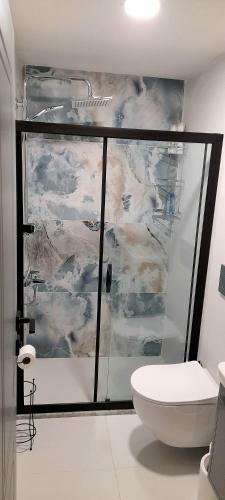 a bathroom with a glass shower with a toilet at AirPort Blue Eye Apartment Dalaman 5 km form AirPort in Dalaman
