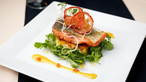 a white plate with a sandwich with lettuce and tomato at Hotel Poniatowski in Radom