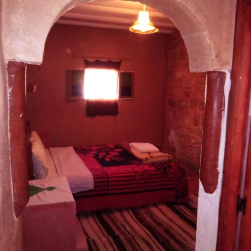 a bedroom with a bed in a room with a window at Dar Zara in Ouarzazate
