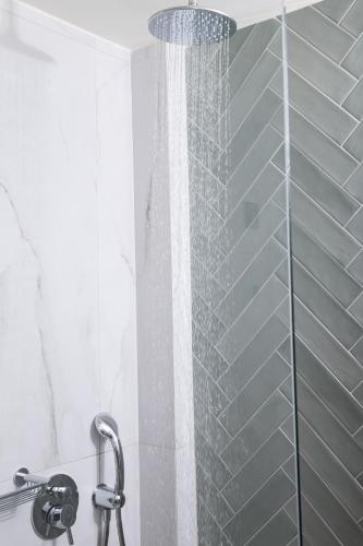 a shower with a glass door in a bathroom at Epoch House & The Orange Shop - Adults Only in Nafplio