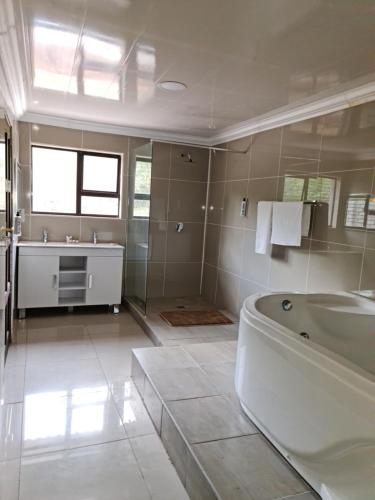 a large bathroom with a tub and a sink at Bela Rest Resort in Bela-Bela