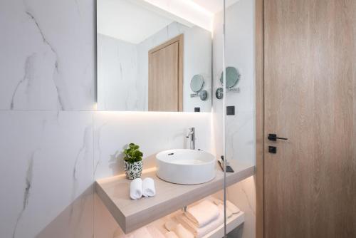 a bathroom with a sink and a mirror at Epoch House & The Orange Shop - Adults Only in Nafplio