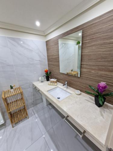 a bathroom with a sink and a mirror at Large terrace with views on the cliffs at Balcon De Los Gigantes in Puerto de Santiago