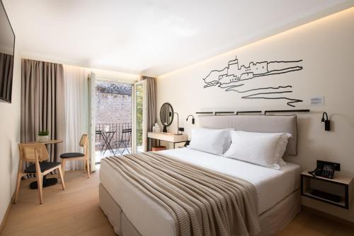 a hotel room with a bed and a balcony at Epoch House & The Orange Shop - Adults Only in Nafplio