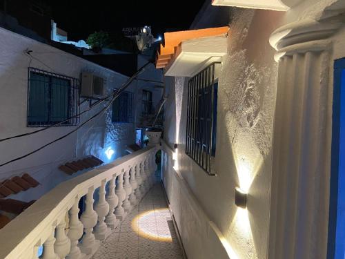 a white building with a balcony at night at Las 4 Estaciones Alojamientos de Ensueño Santorini Doradal in Puerto Triunfo